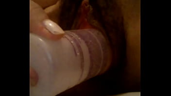 Metiendose botella en el coño