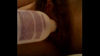 Metiendose botella en el coño