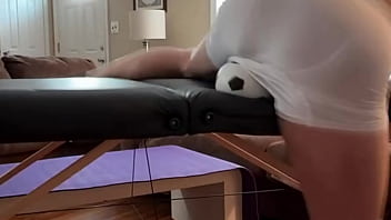 Groin stretch in tight spandex shorts with mini football soccer ball on stool and table slowed down time lapse Groin stretch in tight spandex shorts with mini football soccer ball on stool and table slowed down time lapse