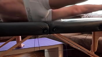 Groin stretch in tight spandex shorts with mini football soccer ball on stool and table slowed down time lapse