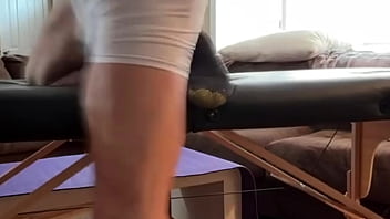 Groin stretch in tight spandex shorts with mini football soccer ball on stool and table slowed down time lapse