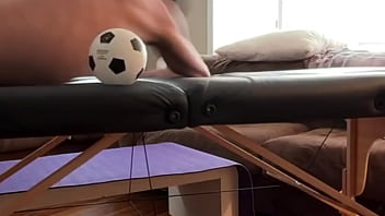 Groin stretch in tight spandex shorts with mini football soccer ball on stool and table slowed down time lapse