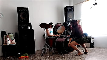 They play the drums for her she dances stripping and showing her ass