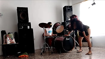 They play the drums for her she dances stripping and showing her ass