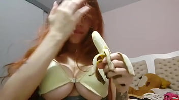 Novinha balançando os peitos com banana na mão