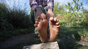 Sexy babe teases her dirty feet outdoors