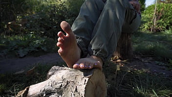 Sexy babe teases her dirty feet outdoors