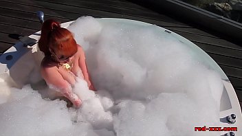 British redhead plays with her pussy outside in the hottub