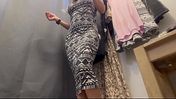 A sexy woman with big breasts and a big ass tries on clothes