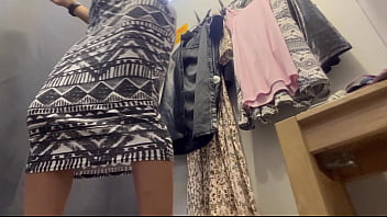 A sexy woman with big breasts and a big ass tries on clothes