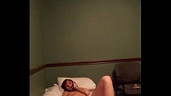 Young girl recording masturbates on bed while talking on the phone
