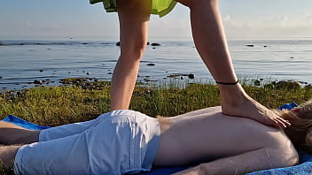 Foot massage by girl with long toes long slim legs in skirt