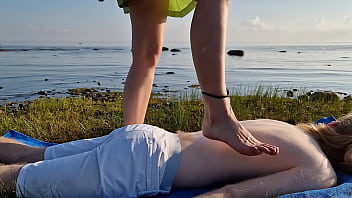 Foot massage by girl with long toes long slim legs in skirt