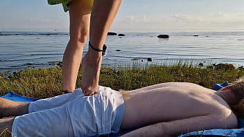 Foot massage by girl with long toes long slim legs in skirt