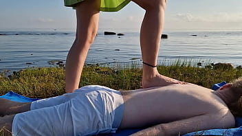 Foot massage by girl with long toes long slim legs in skirt