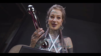 Tattoo slut sinks a thick metal toy deep into her hole