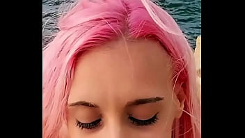 Cumshot partially lands on her face while the rest blends with the sea