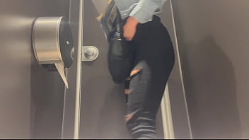 A woman pees in a public toilet