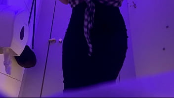 A woman pees in a public toilet