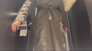 A woman pees in a public toilet